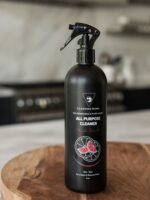 Cleaning Mama plant-based Fresh Scent All Purpose Cleaner in a black spray bottle displayed on a wooden board in a modern kitchen.