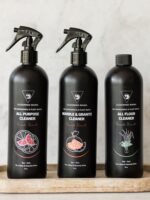 Close-up of the Cleaning Mama Fresh Scent trio featuring All Purpose, Marble & Granite and All Floor Cleaner in black bottles on a wooden tray.