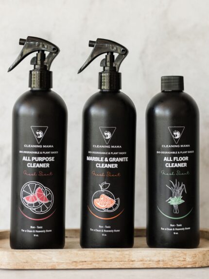 Close-up of the Cleaning Mama Fresh Scent trio featuring All Purpose, Marble & Granite and All Floor Cleaner in black bottles on a wooden tray.