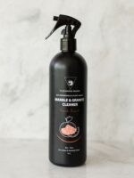 Cleaning Mama non-toxic, plant-based Fresh Scent Marble & Granite Cleaner in a black spray bottle sitting on a marble countertop.