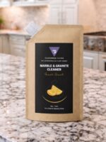 Cleaning Mama plant-based Fresh Scent Marble & Granite Cleaner refill pouch displayed on a granite kitchen countertop.