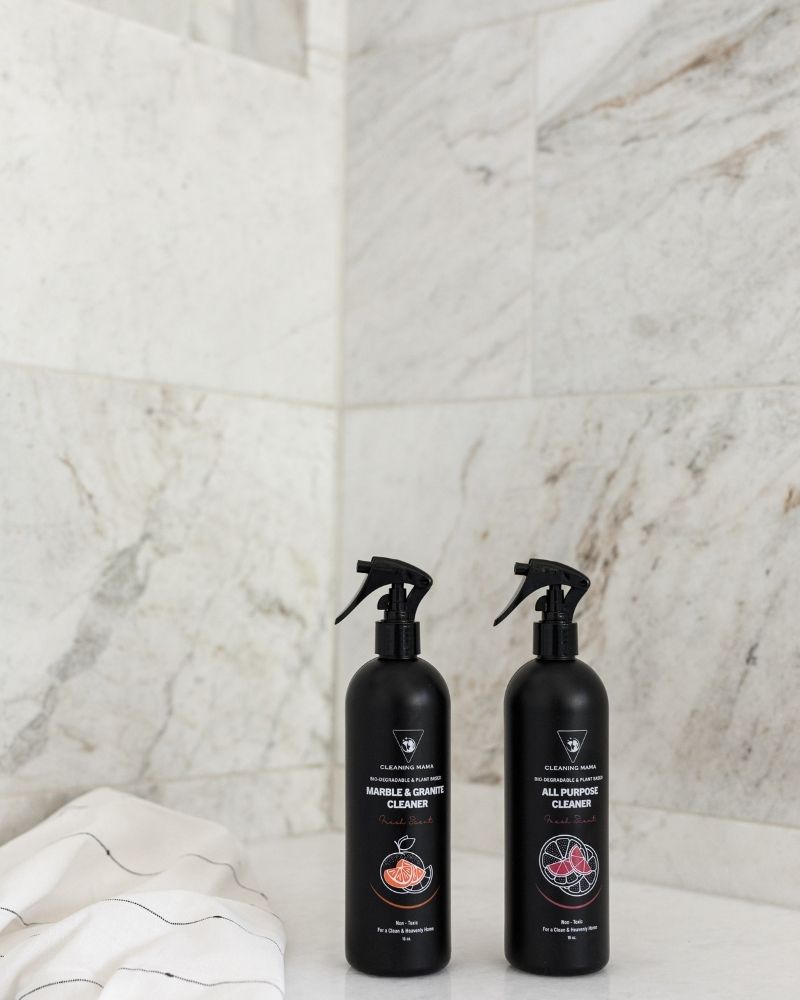 Cleaning Mama All Purpose and Marble & Granite cleaners displayed in a marble shower