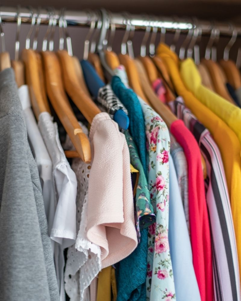 Organized closet with clothing on wooden hangers during a seasonal wardrobe reset