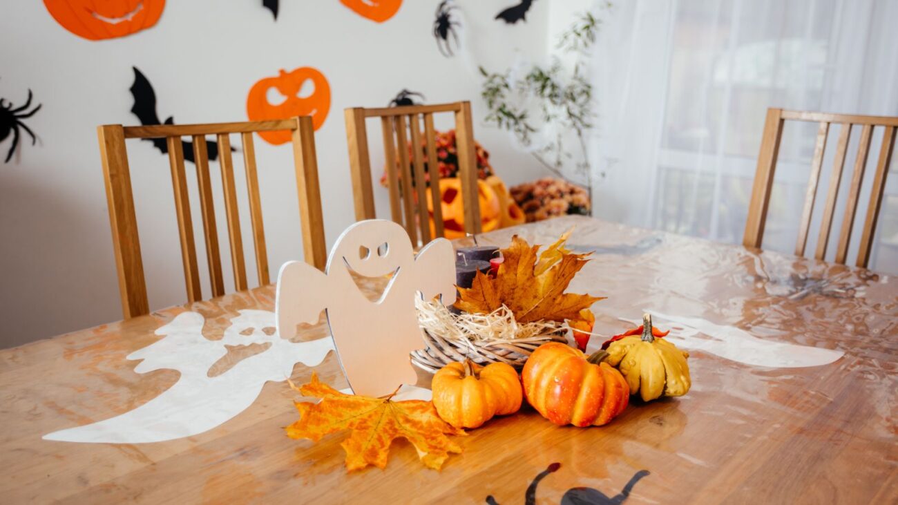 Halloween party table decorated with pumpkins, leaves and ghost decor