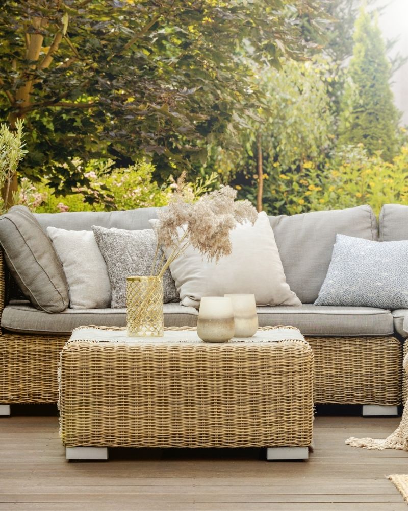 Clean outdoor patio with wicker furniture and neutral cushions ready for fall
